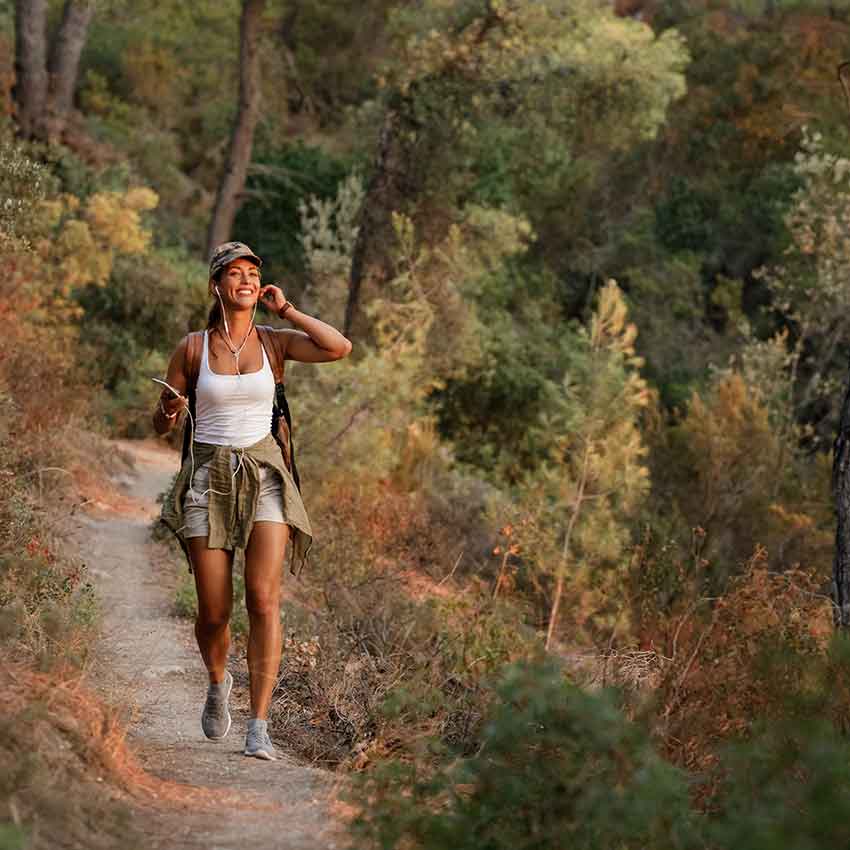 young-happy-woman-hiking-in-the-mountains-while-using-her-mobile-phone-1